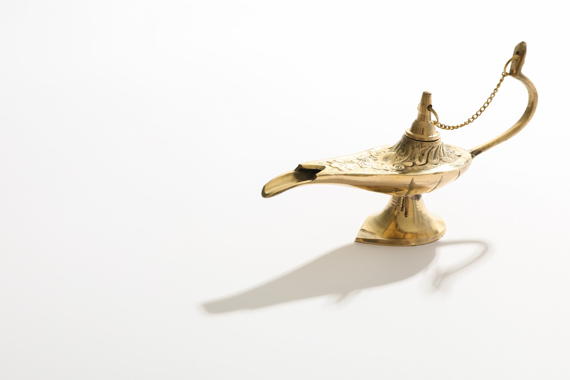 Brass lamp on a white surface — symbol of insight and wisdom
